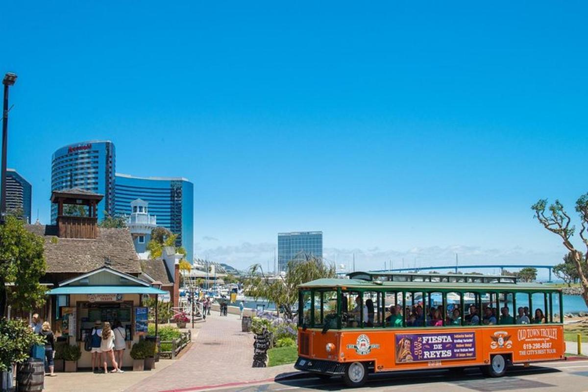 an orange bus driving down a street next to a city