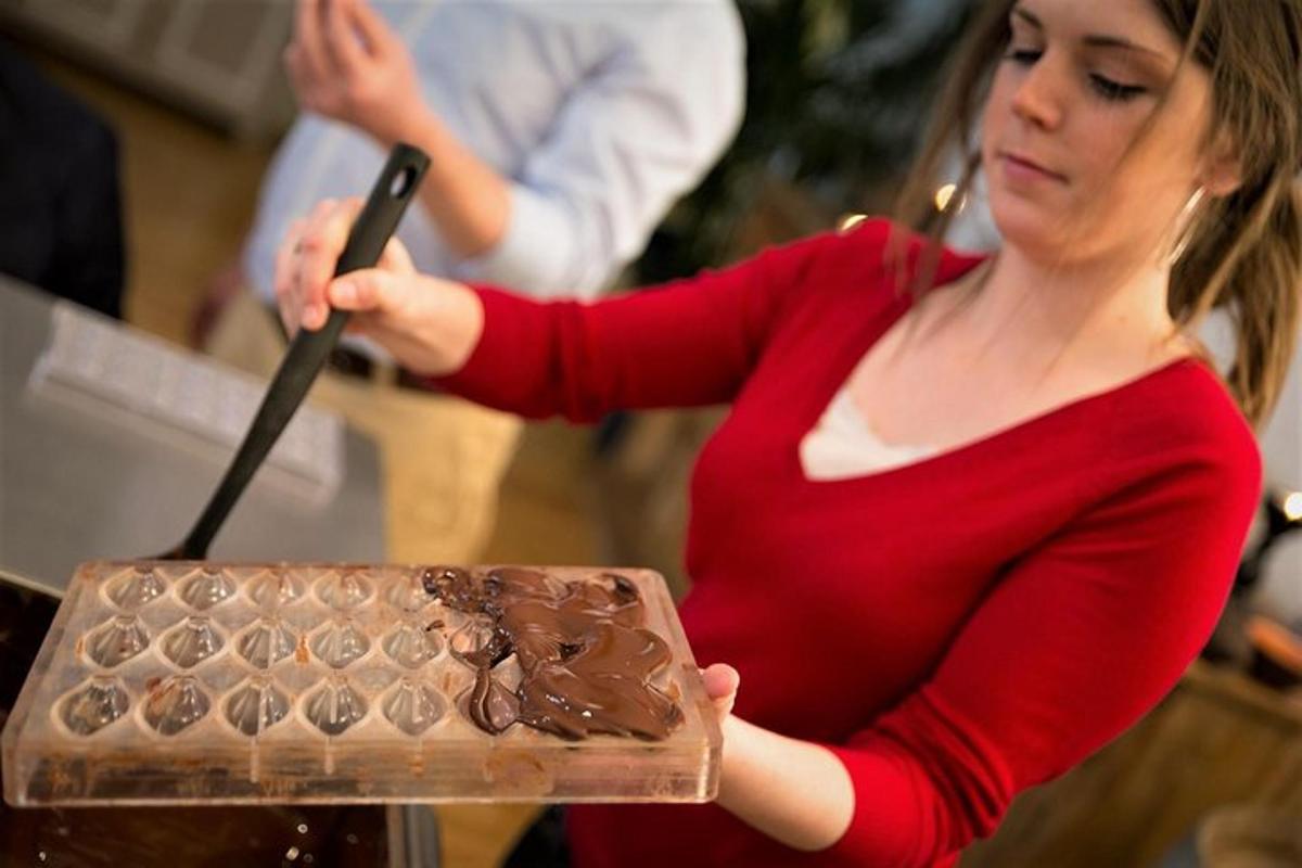 una donna che tiene in mano un pezzo di torta al cioccolato