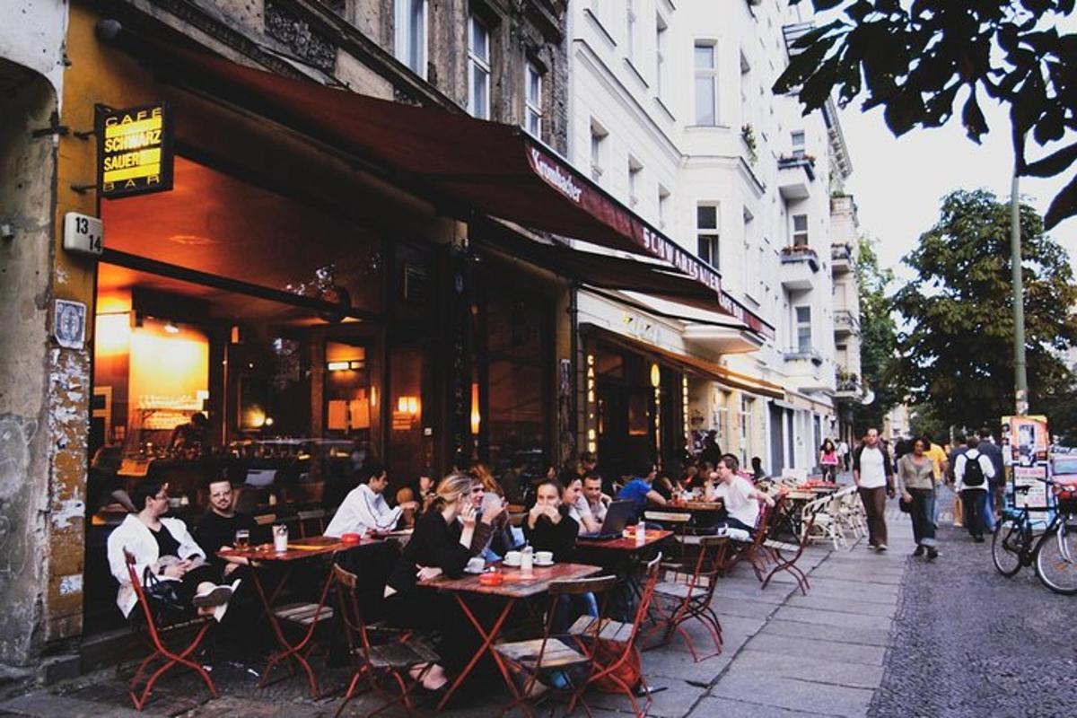 skupina lidí sedících u stolů před restaurací