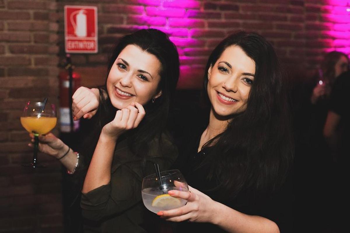 two women holding a drink in a bar