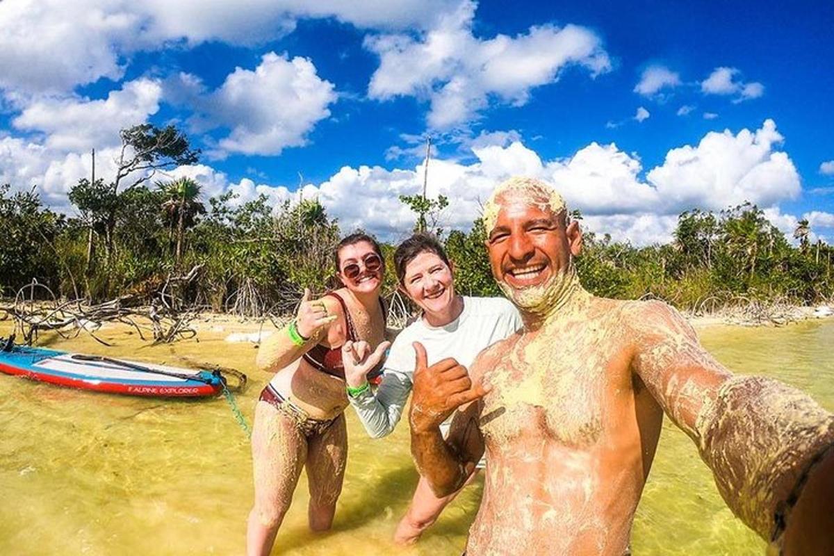 tre persone in piedi nell'acqua su una spiaggia