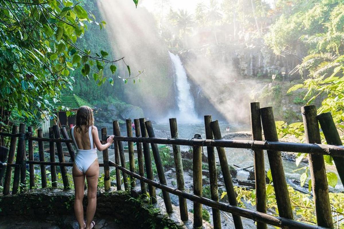 Kona í hvítum bikiní horfir á foss