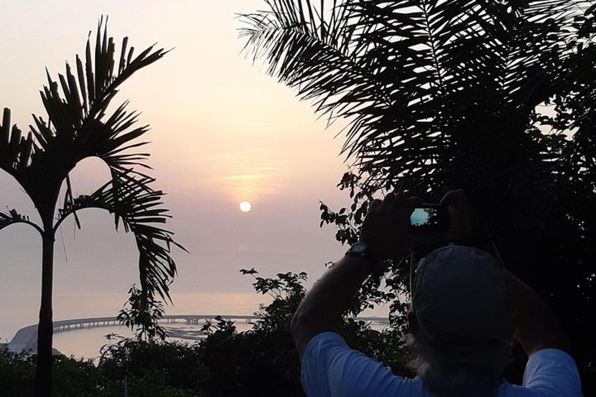 osoba fotografující západ slunce fotoaparátem