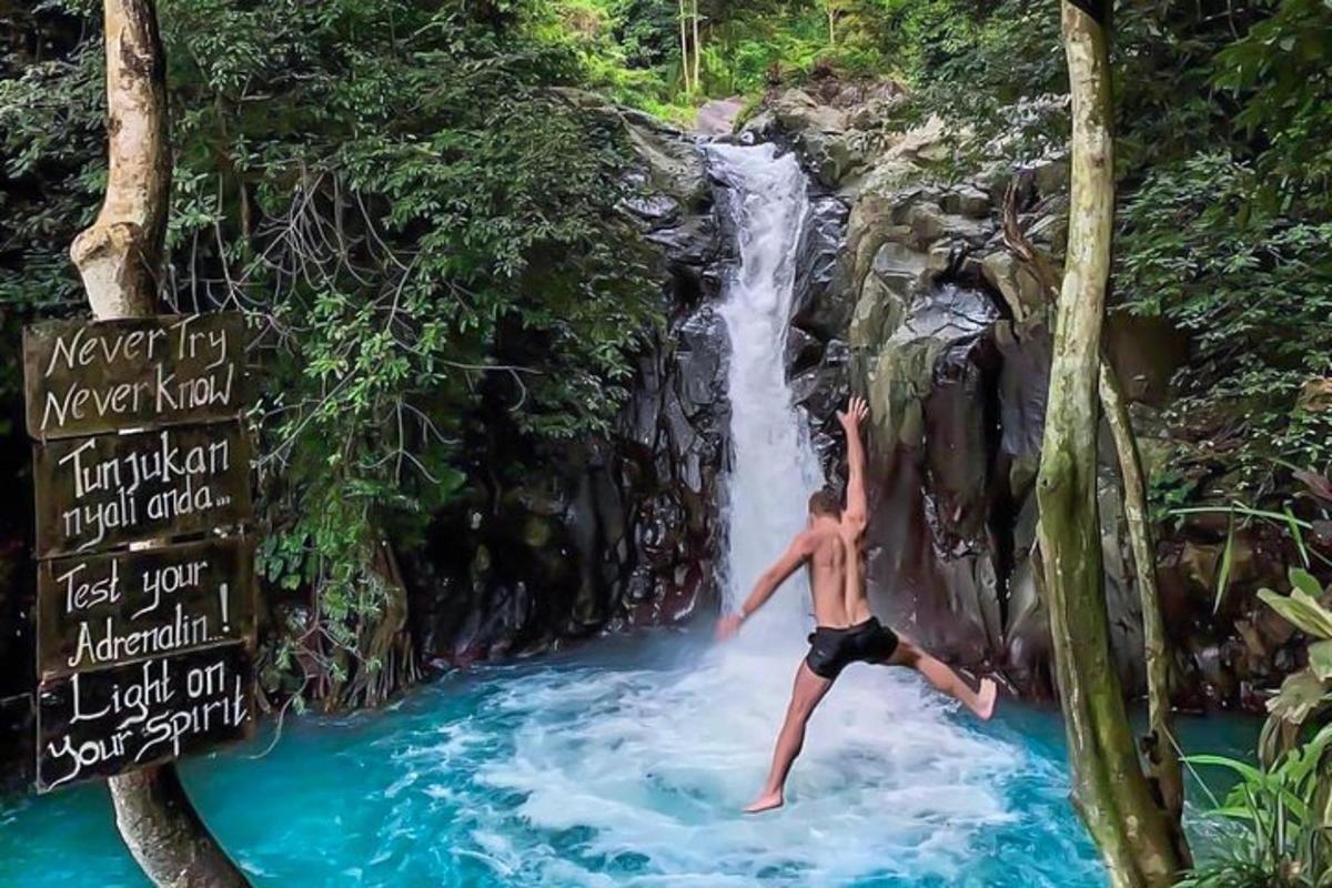 човек скаче са водопада у воду