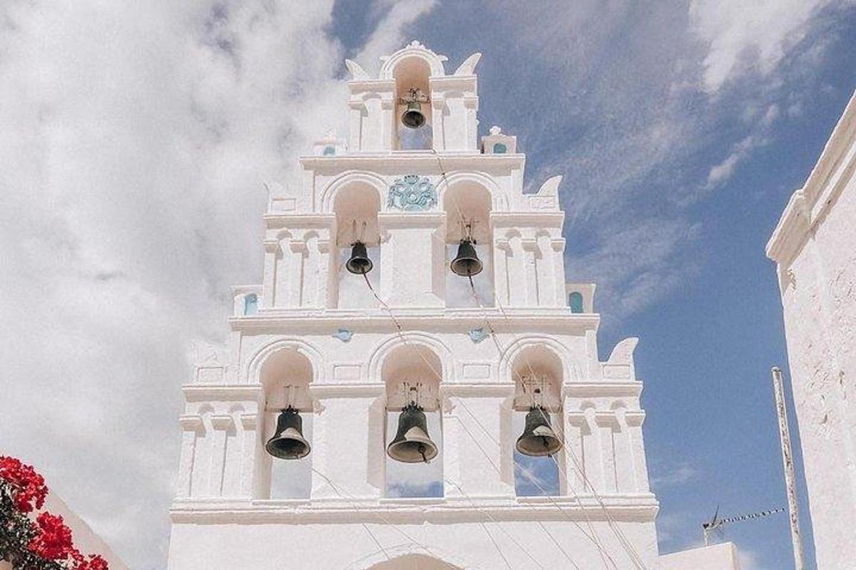 una torre de rellotge blanca i alta amb campanes