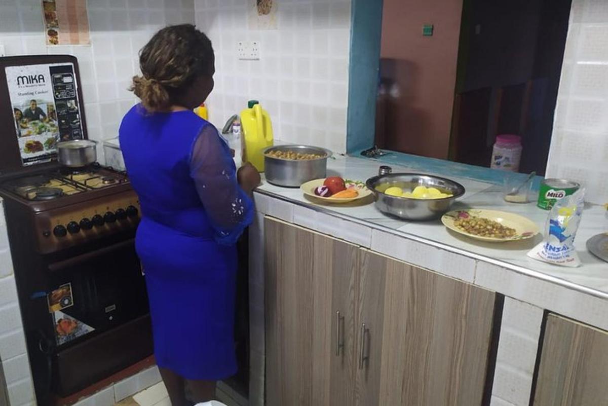 a woman standing in a kitchen preparing food