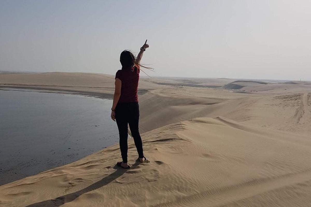 a woman standing in the desert with her arm in the air