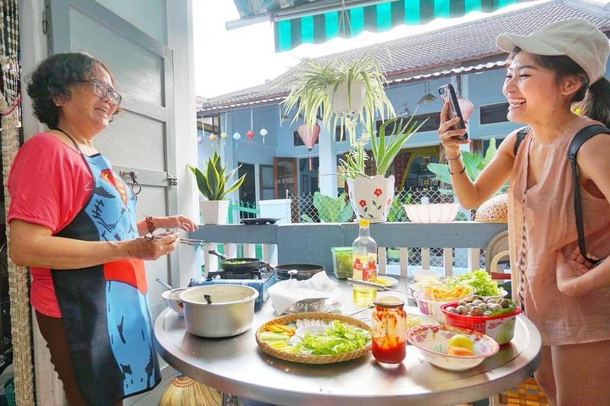 two women standing in front of a table with food
