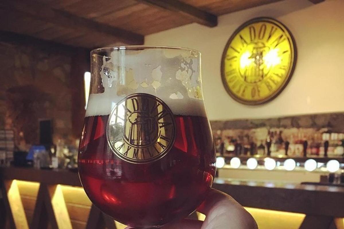 Una mano sosteniendo una copa de vino con un reloj
