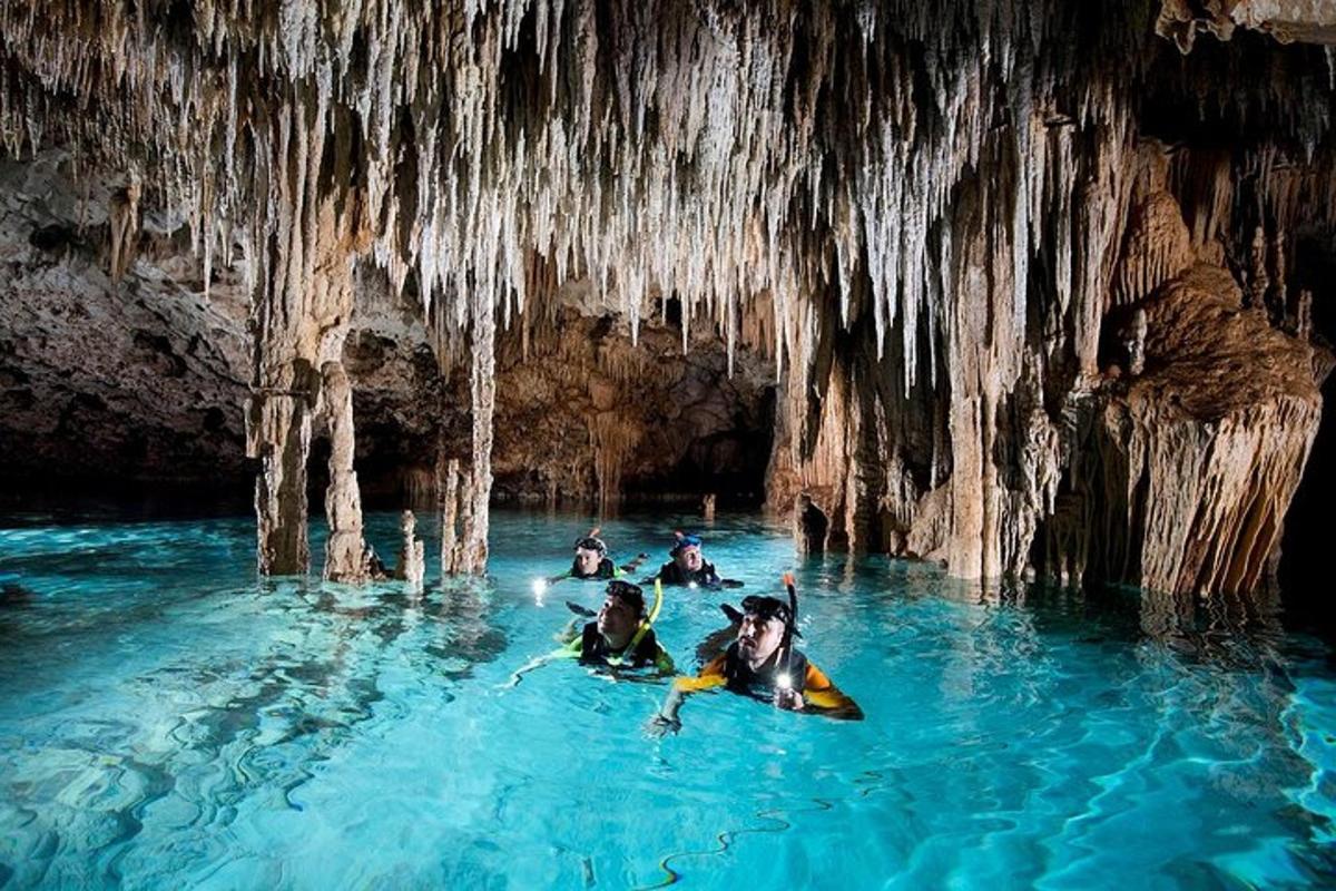 a group of people in the water in a cave