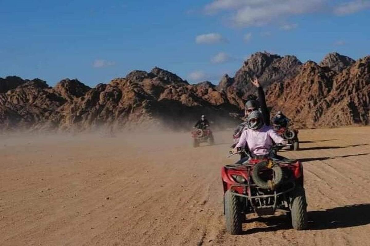 sekelompok orang mengendarai sepeda motor di padang pasir