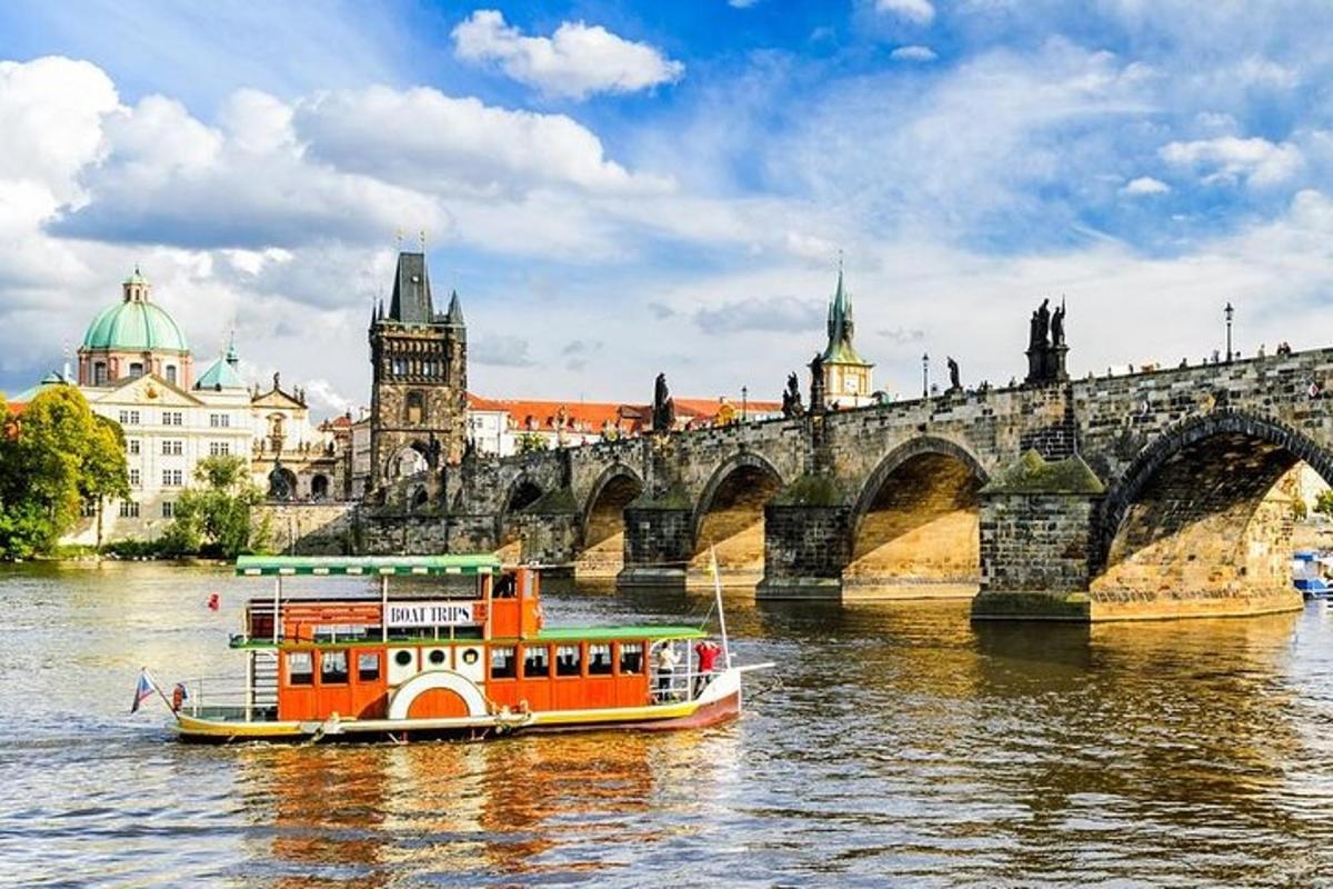 oranžová loď na řece před mostem