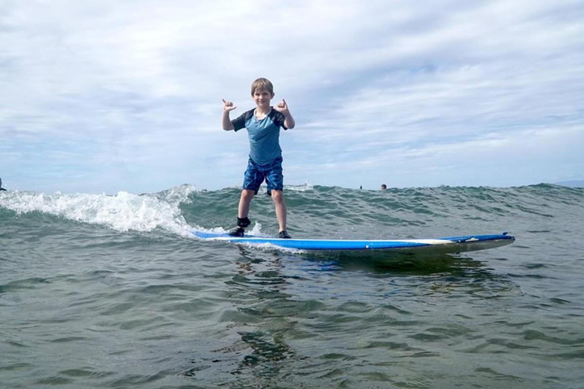 un noi jove dempeus sobre una taula de surf a l'oceà
