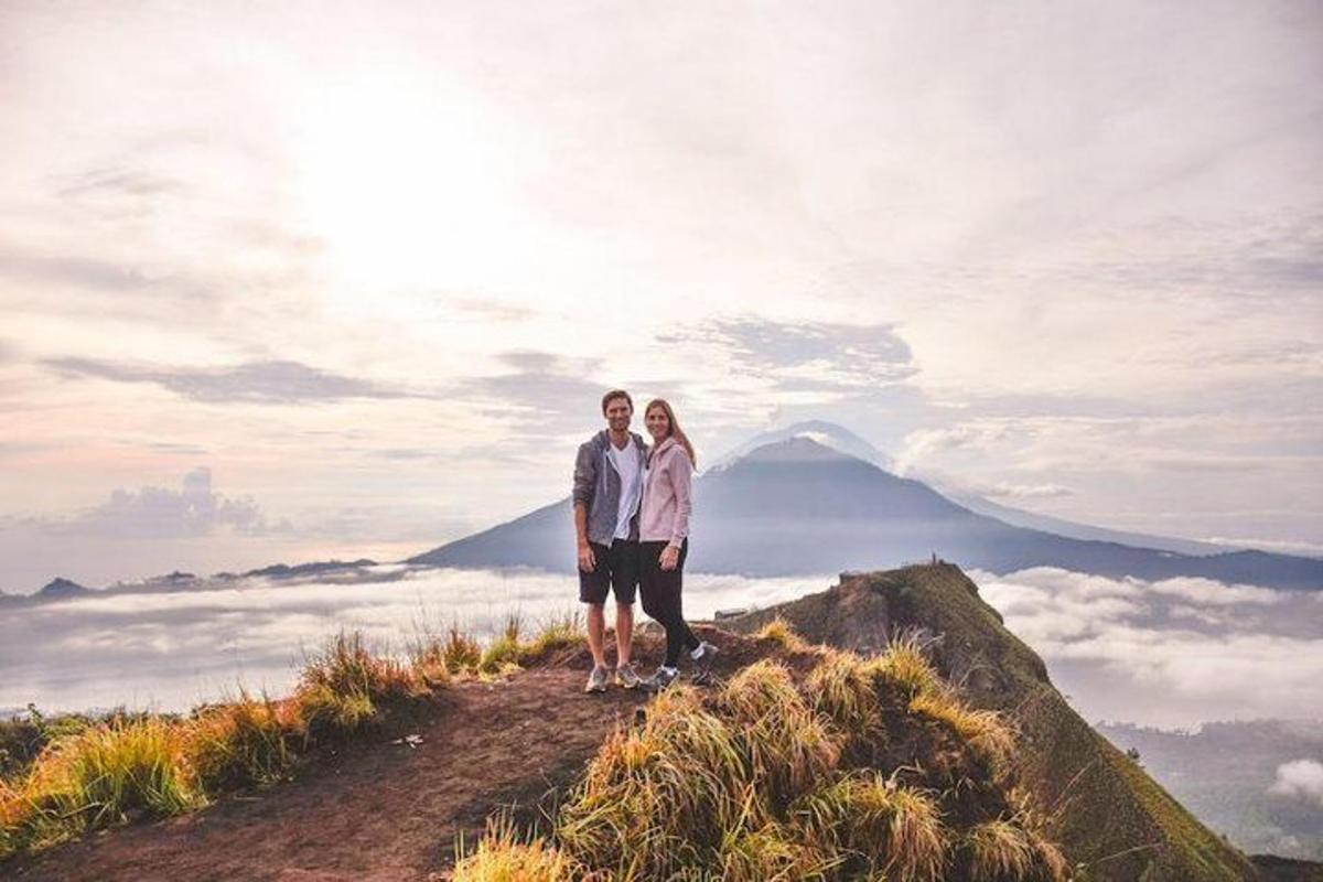 a man and woman standing on top of a mountain