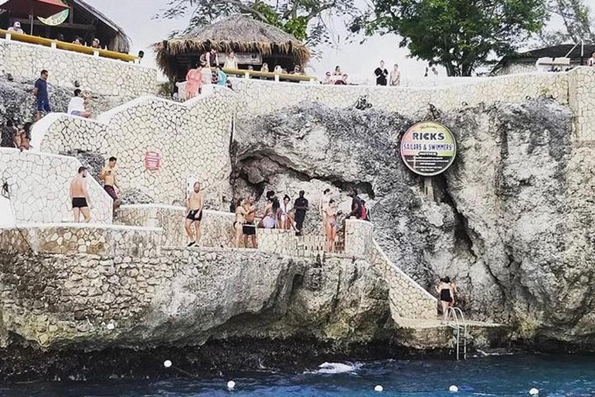 група људи који стоје на каменом зиду близу воде