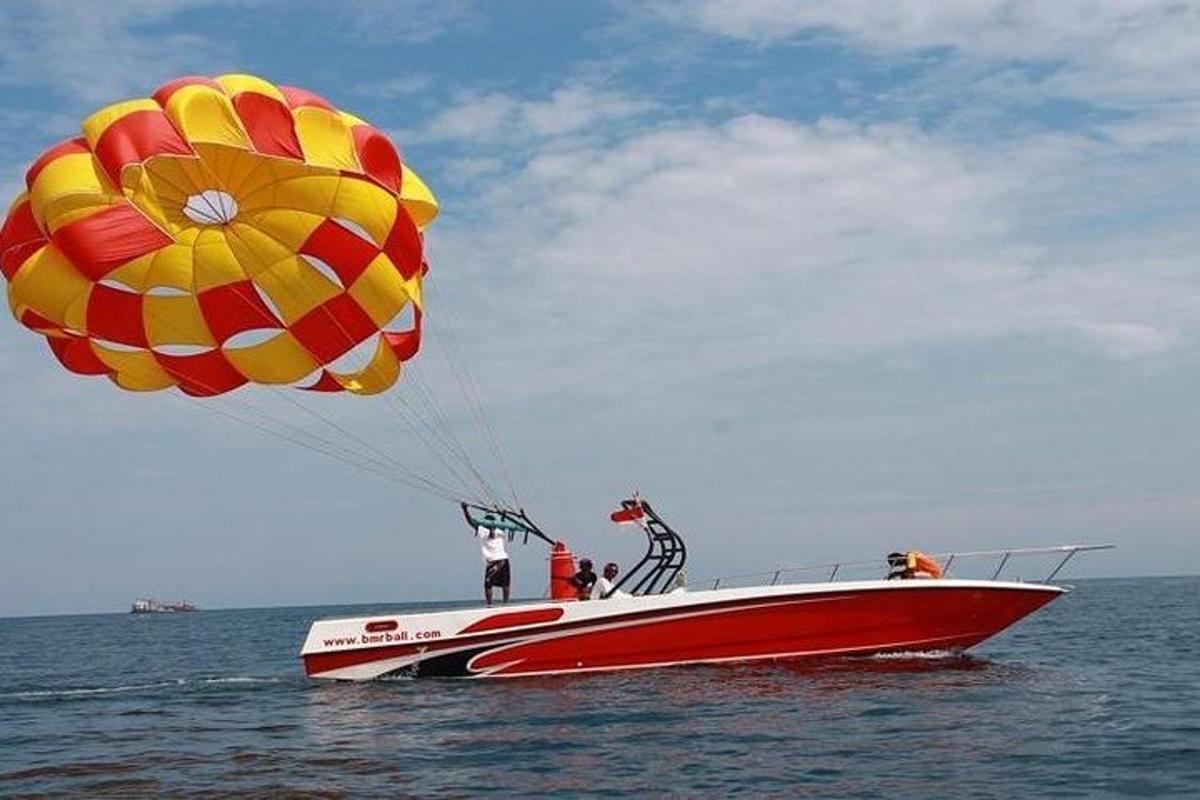 a man riding a parachute on a boat in the water