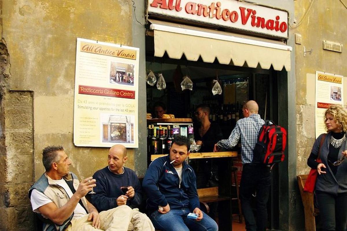 un gruppo di uomini seduti davanti a un negozio