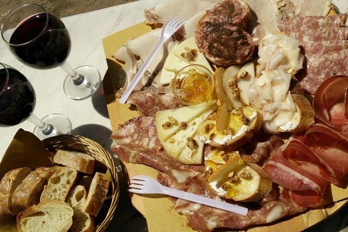 ein Tisch mit einem Teller Essen und Gläsern Wein