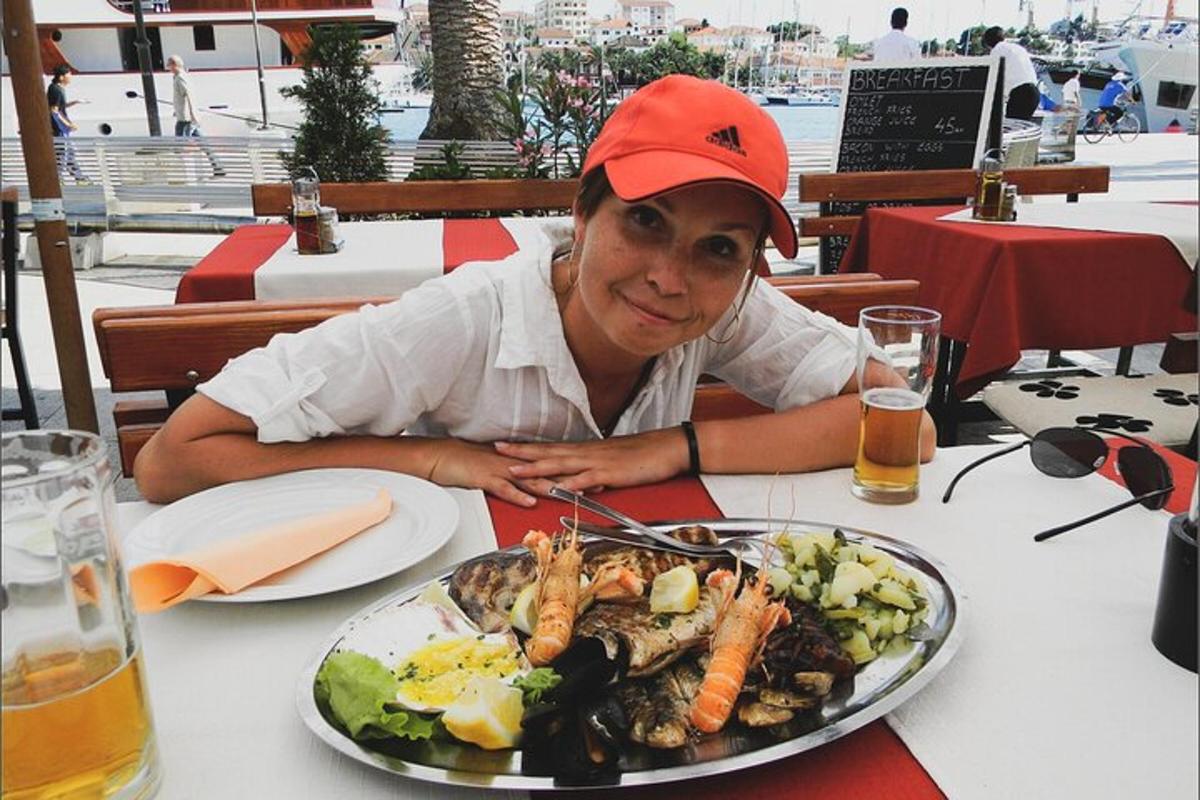 žena sedící u stolu s talířem jídla