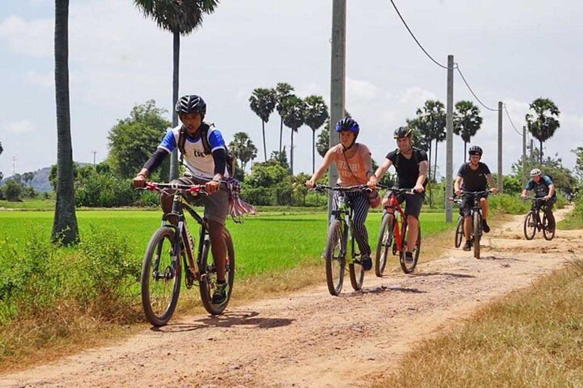 a group of people riding bikes down a dirt road