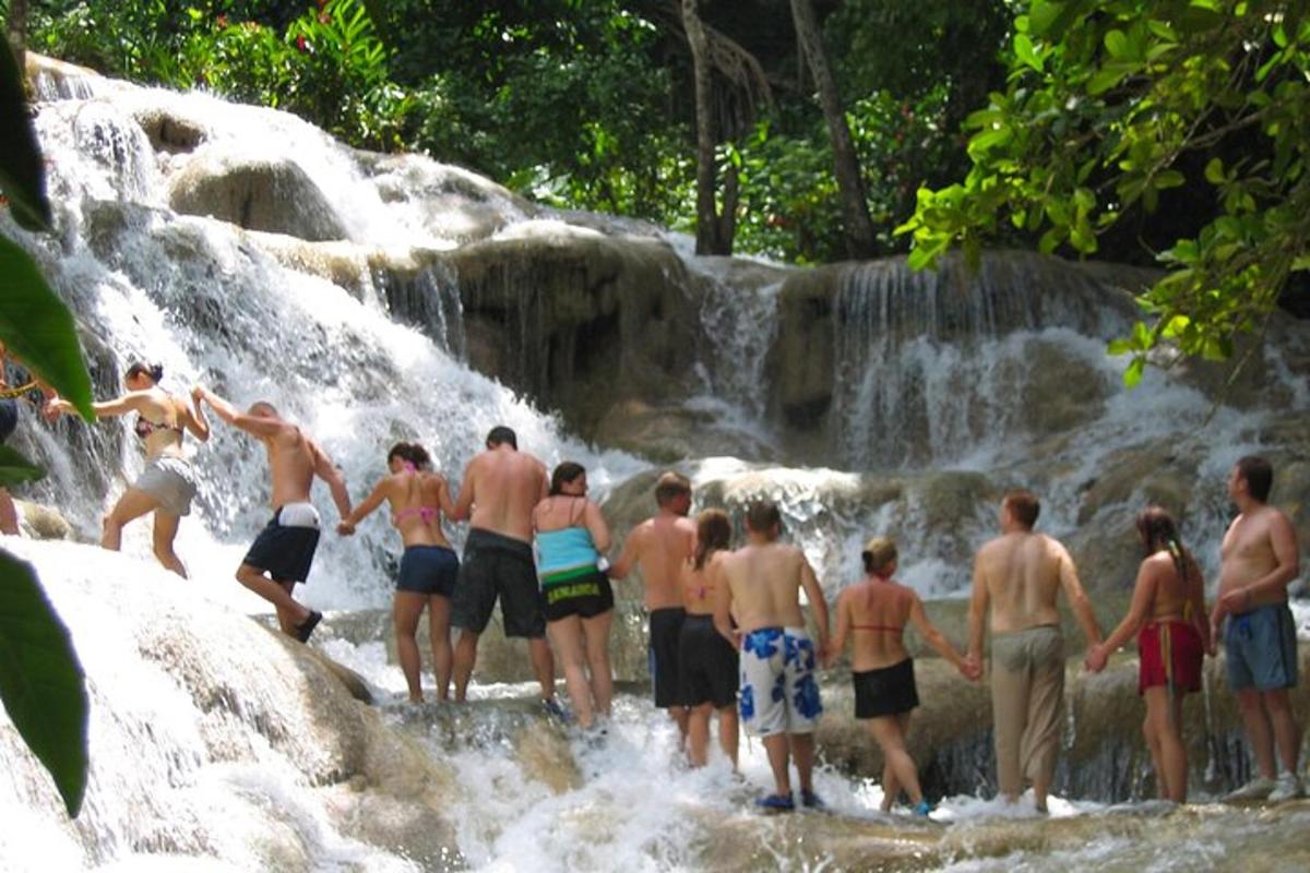 sekelompok orang berdiri di depan air terjun