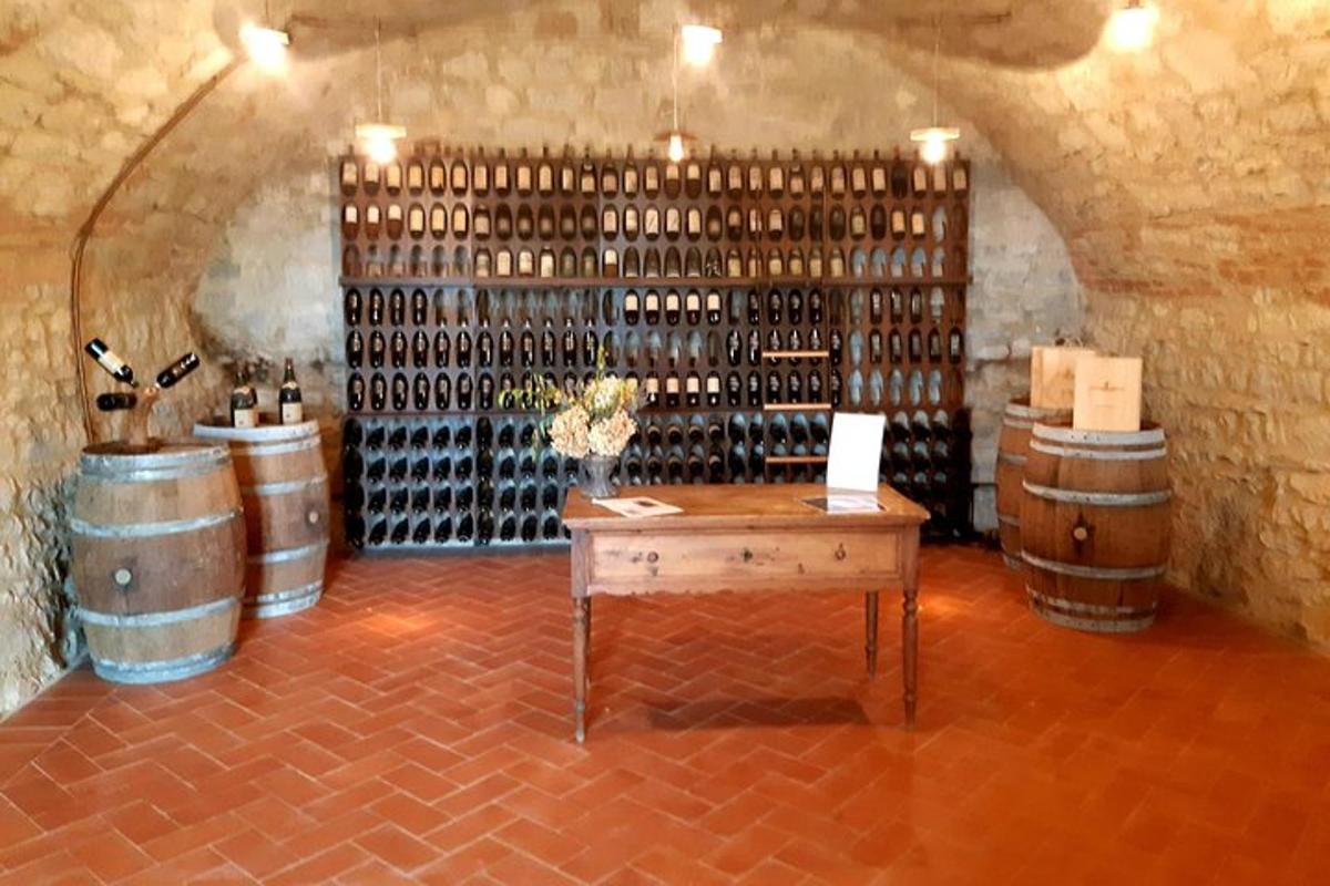 una stanza con un mucchio di botti di vino e un tavolo