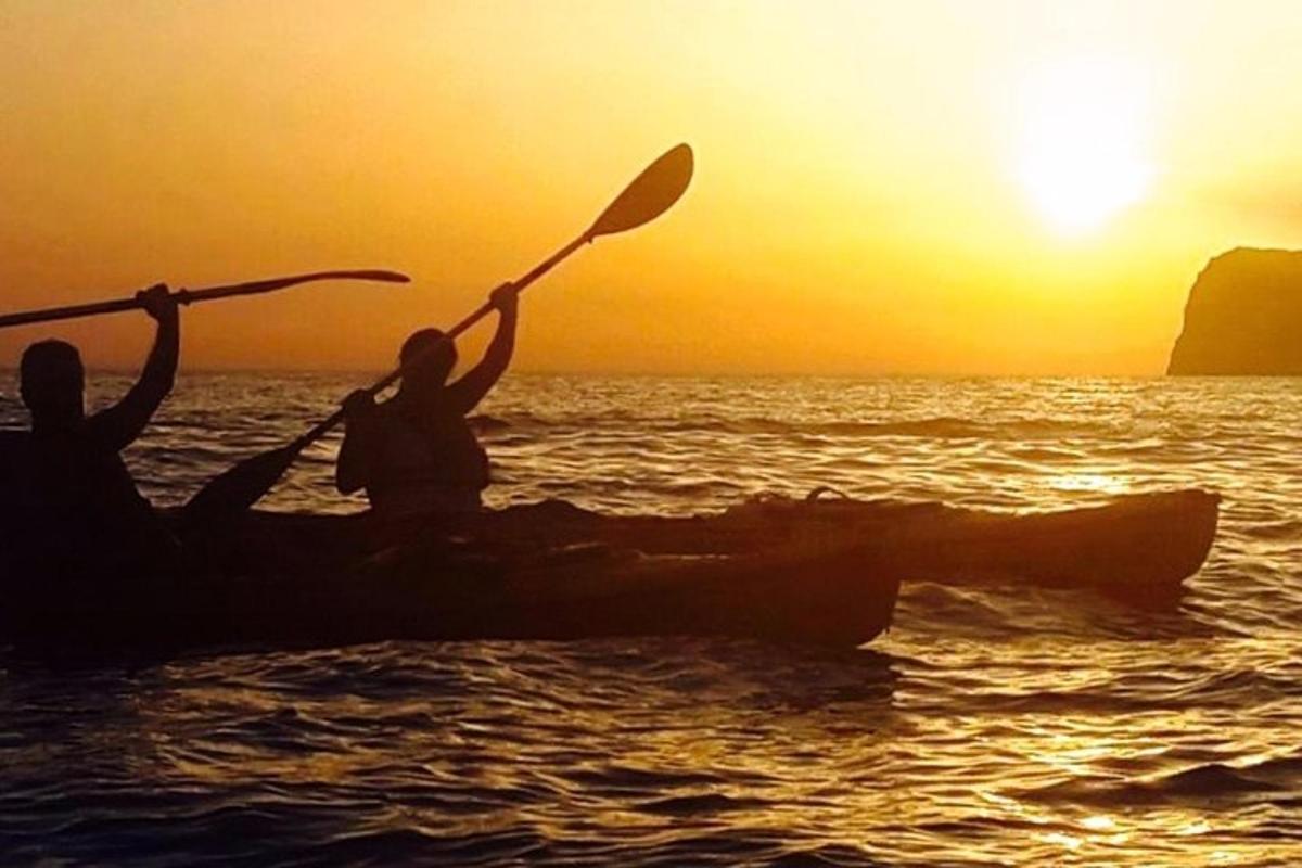 dua orang dalam sampan di lautan pada waktu matahari terbenam