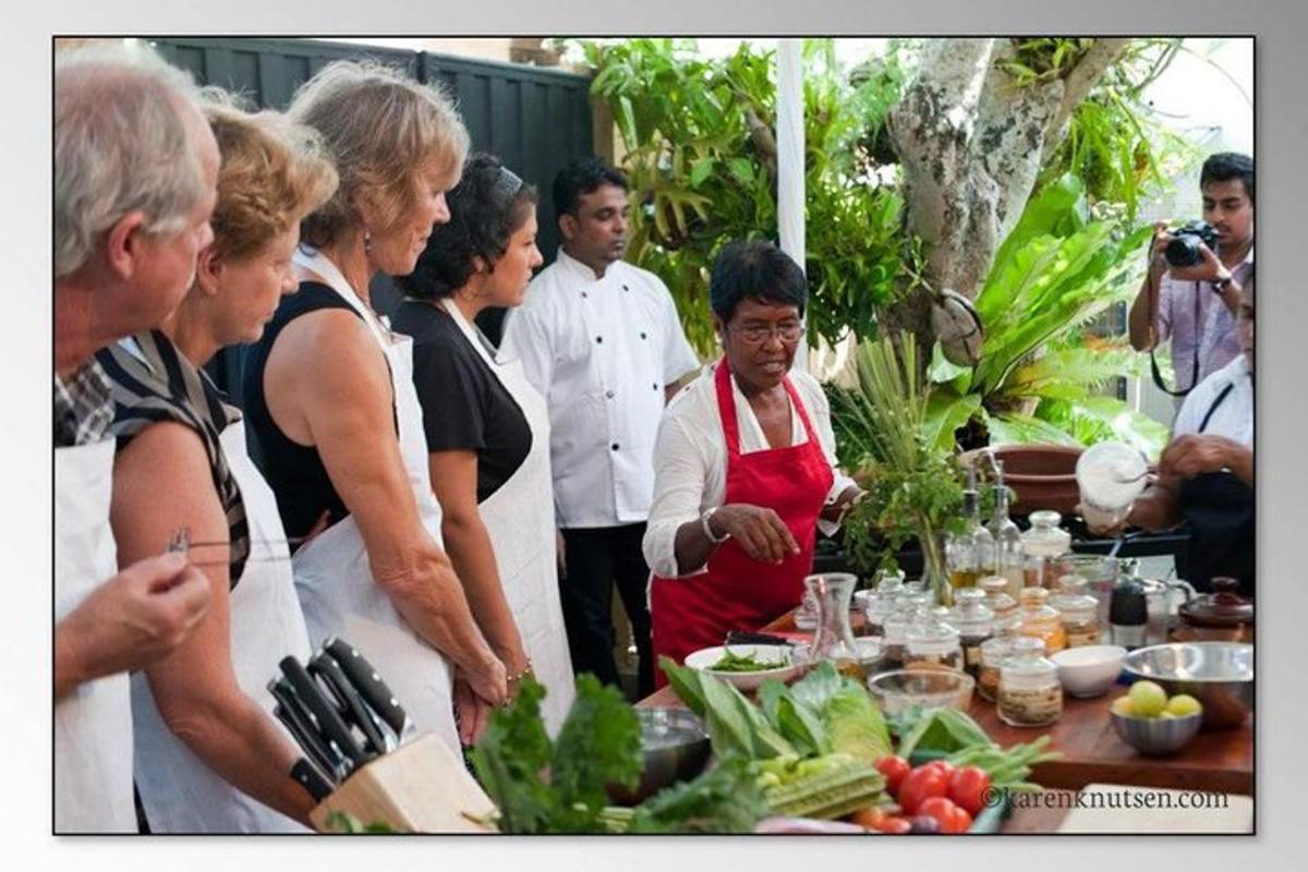 a group of people standing around a table with food