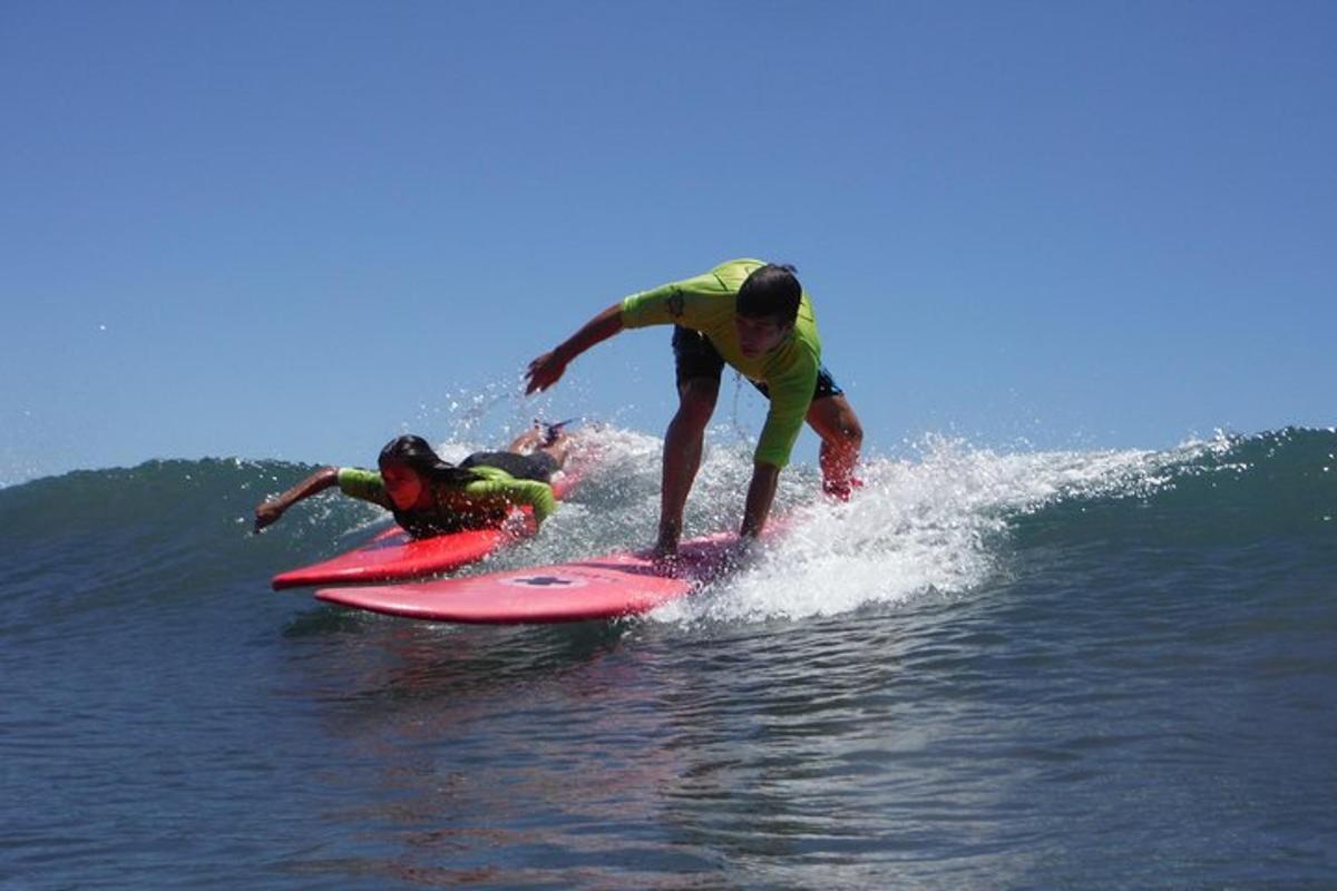 due persone cavalcano un'onda su tavole da surf nell'oceano