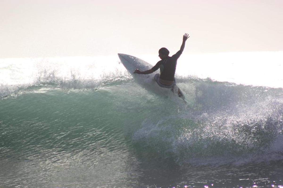 un uomo che cavalca un'onda su una tavola da surf nell'oceano