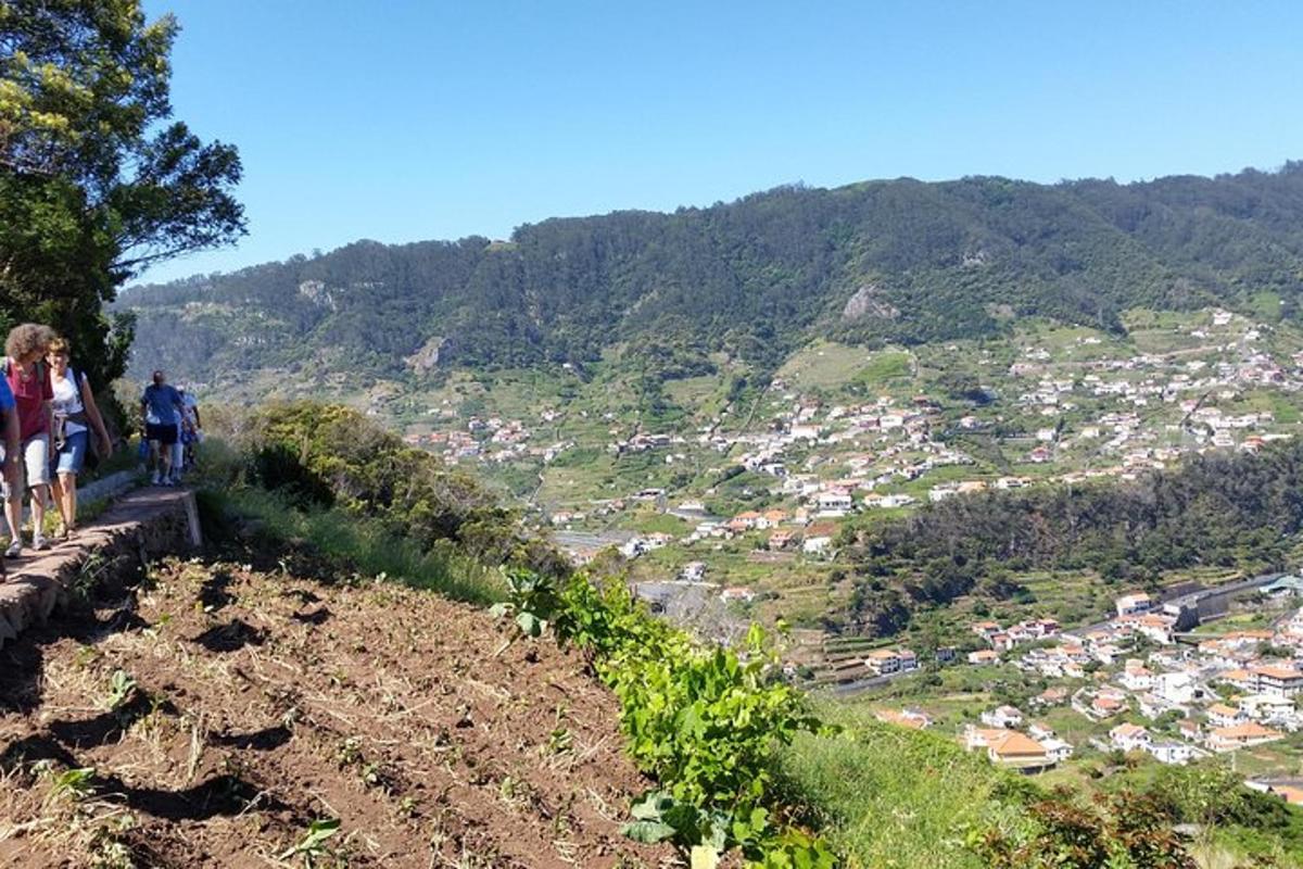 two people standing on top of a hill overlooking a city