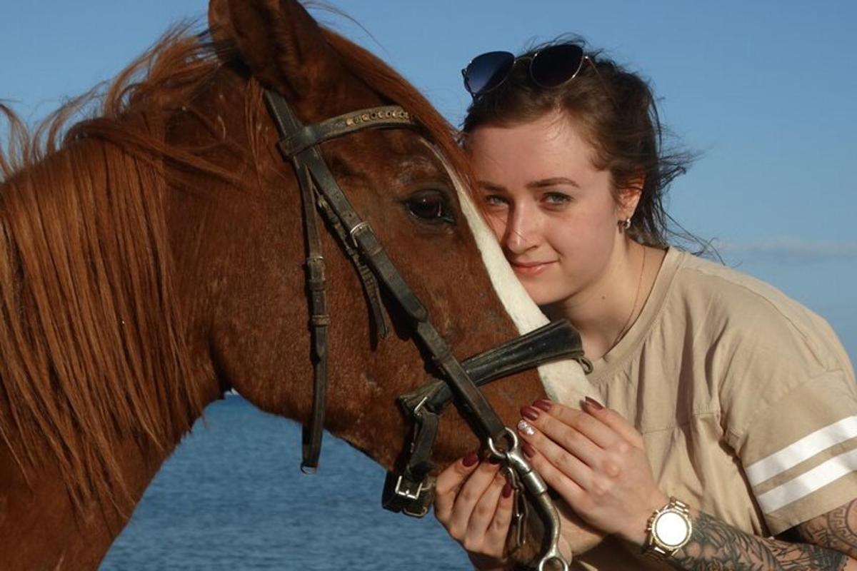 kona stendur við hlið brúns hests