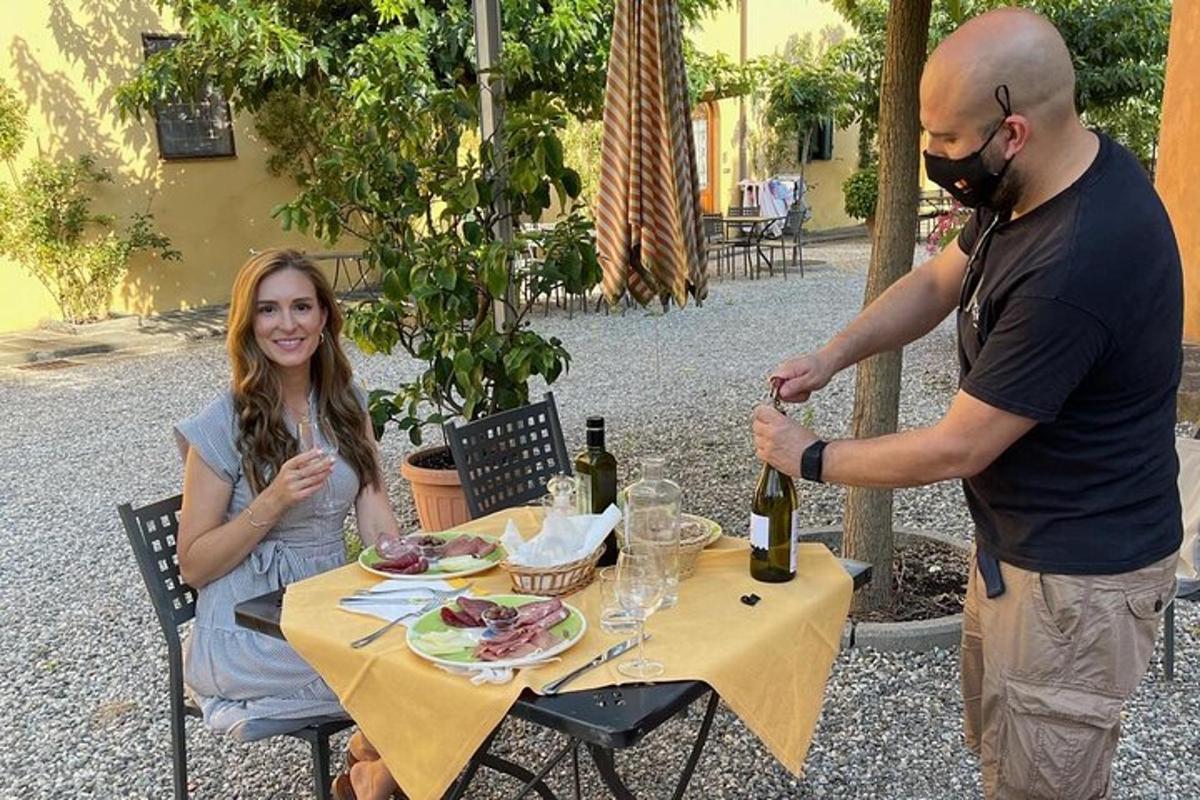 un home i una dona asseguts a una taula amb ampolles de vi