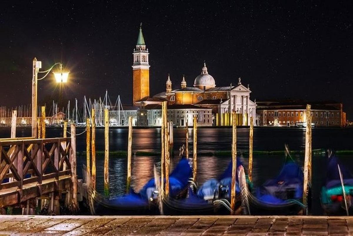 un gruppo di gondole in acqua di notte