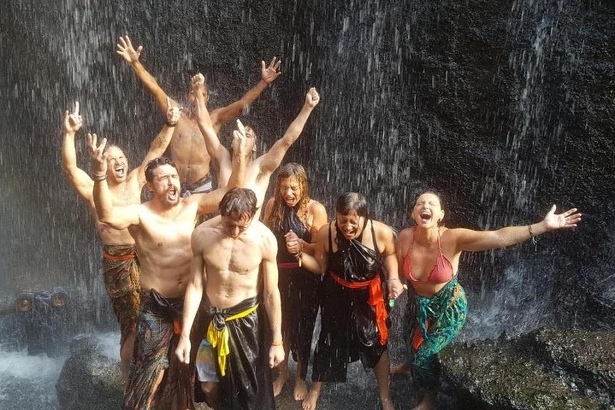 sekelompok orang berdiri di depan air terjun
