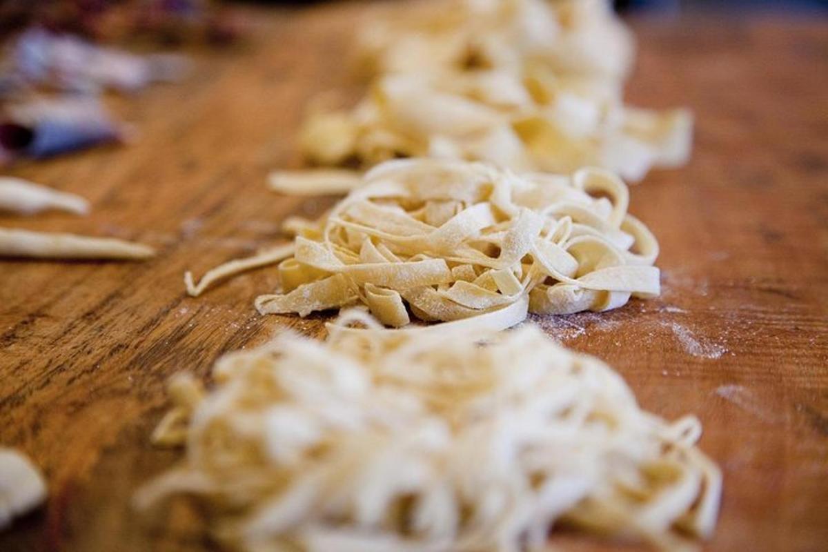 una pila de pasta sobre una tabla de cortar de madera