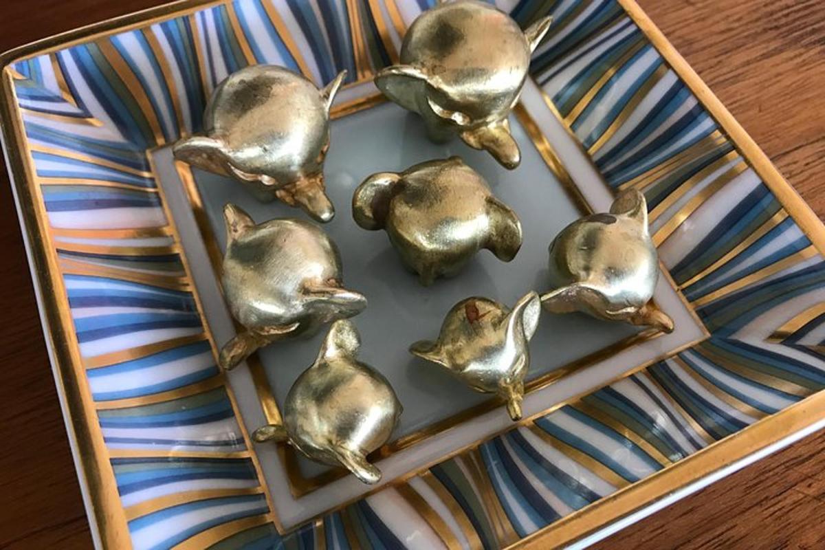a group of brass birds sitting on a tray