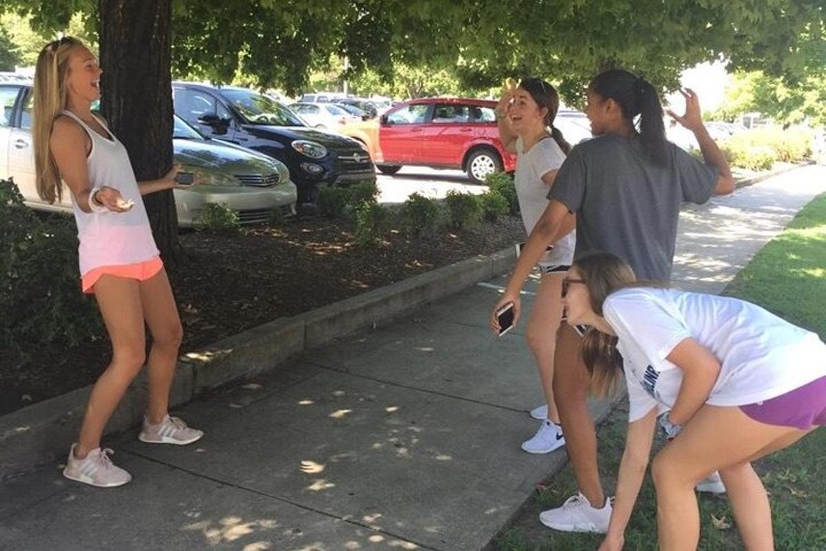 um grupo de jovens mulheres em pé na calçada