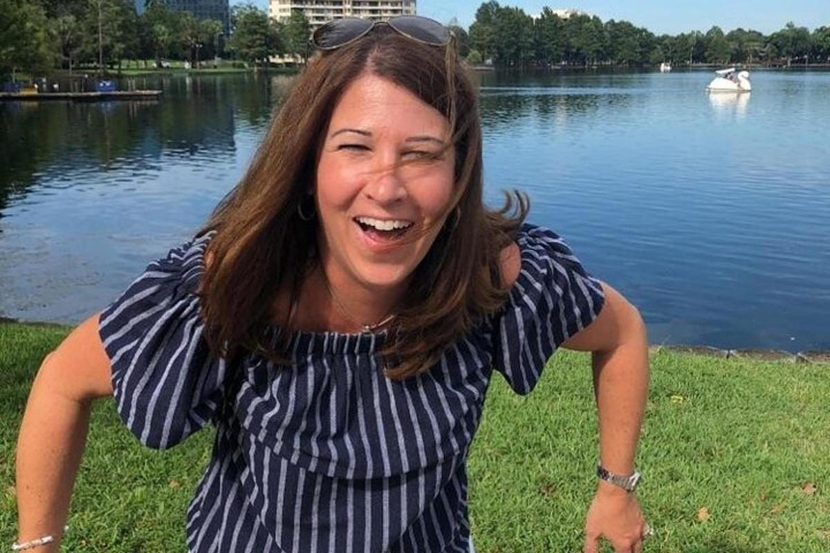 una donna con un abito a righe in piedi davanti a un lago