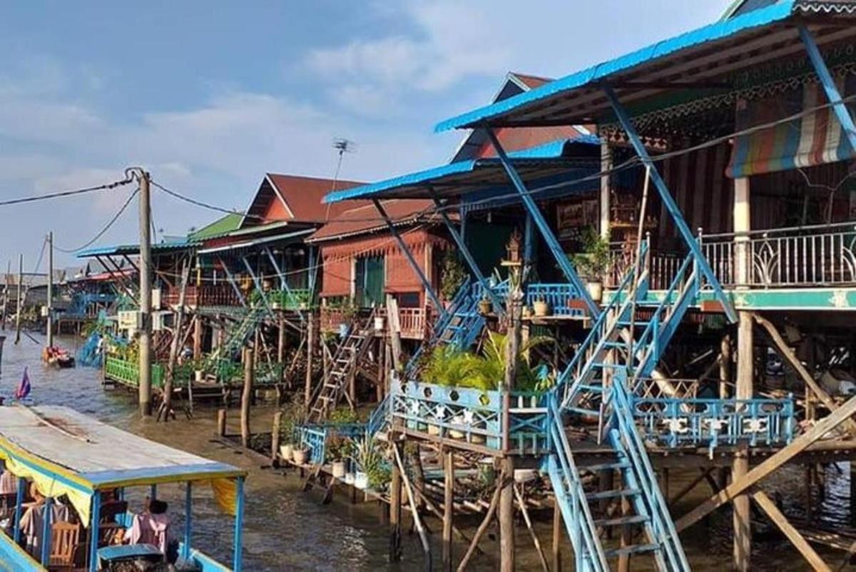 một nhóm nhà trên mặt nước cạnh một con sông