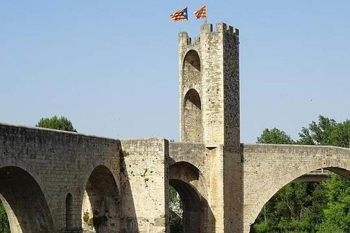 μια πέτρινη γέφυρα με δύο σημαίες στην κορυφή της