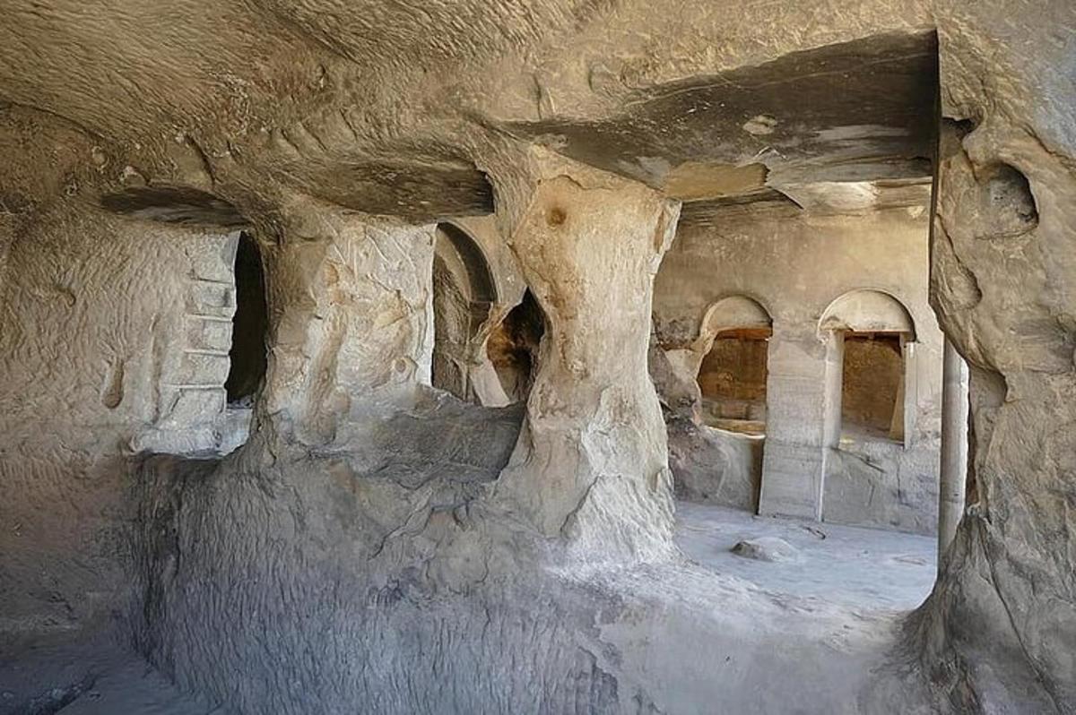 una stanza in una grotta con un muro di pietra