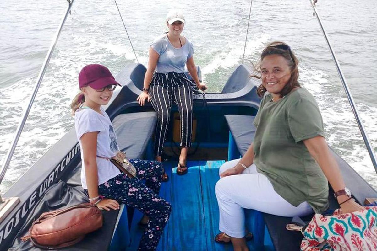 tři ženy sedící na zadní straně lodi