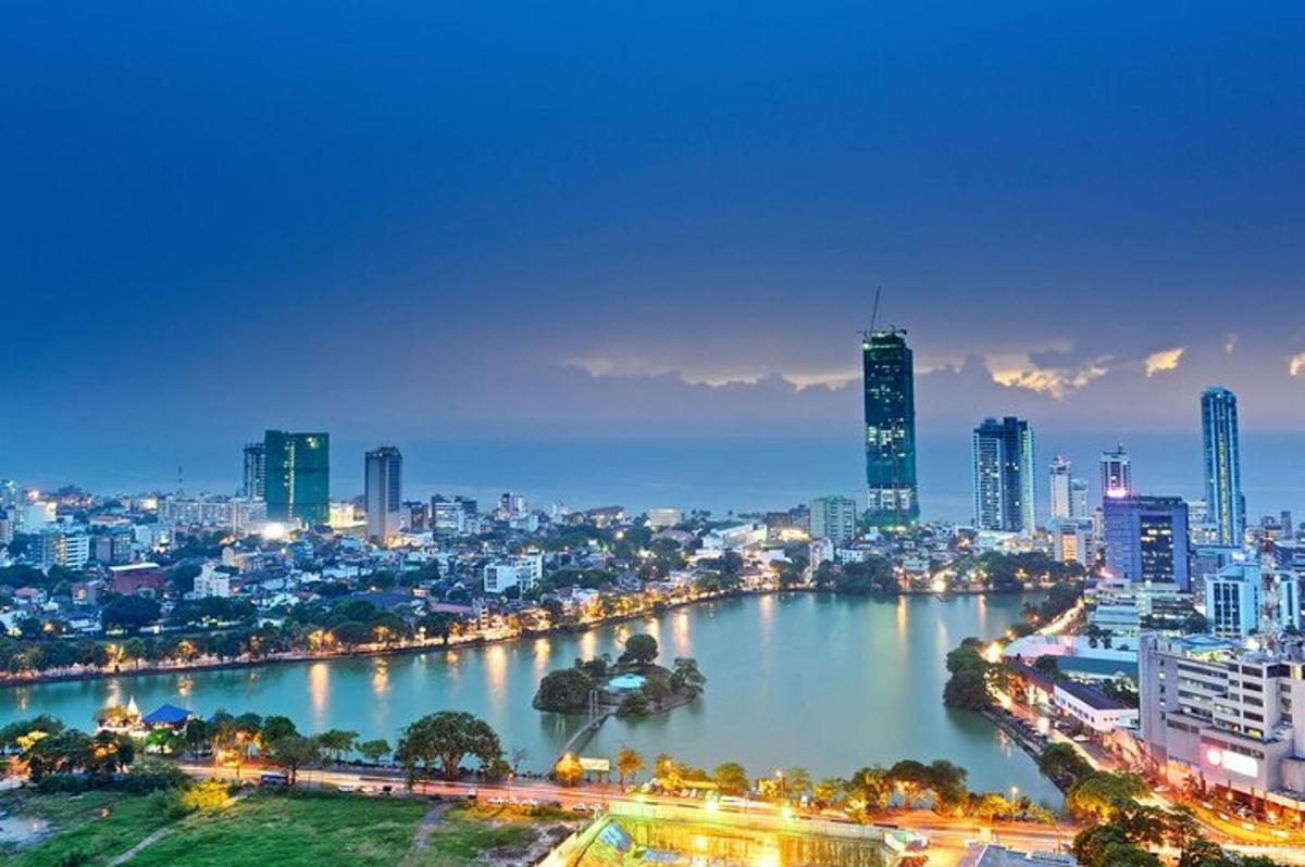 uno skyline di una città di notte con un fiume e degli edifici