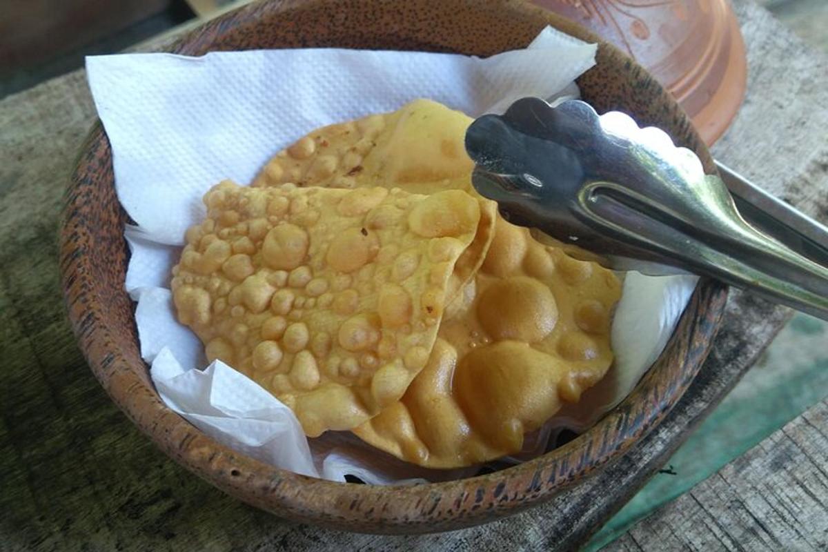 una ciotola di cibo con patatine di mais e un paio di pinze