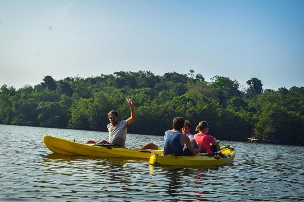 un grup de oameni stând într-o barcă galbenă pe un lac
