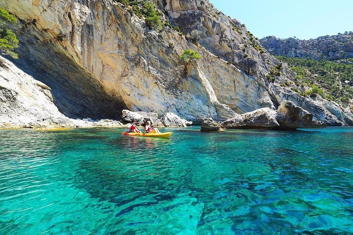 Δύο άτομα σε ένα καγιάκ στο νερό κοντά σε ένα βουνό