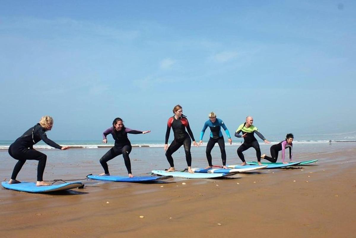 a group of people standing on surfboards on the beach