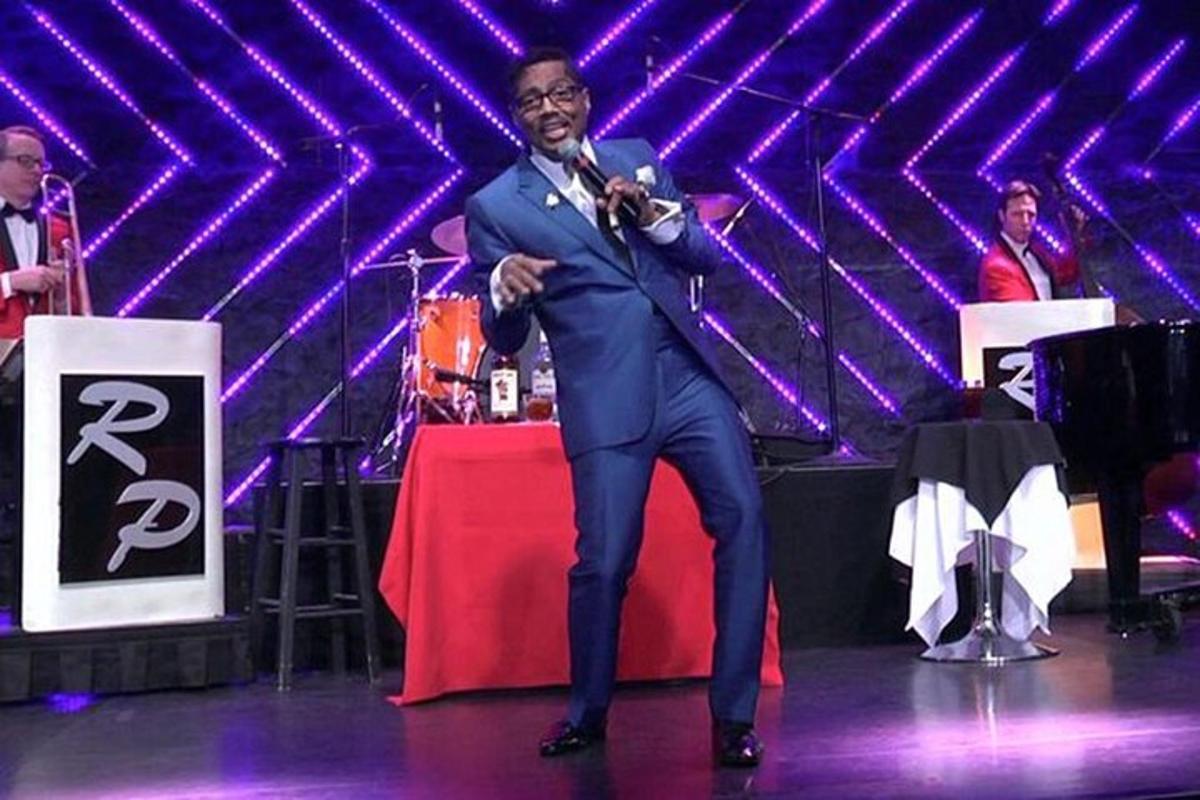 a man in a suit speaking into a microphone on a stage