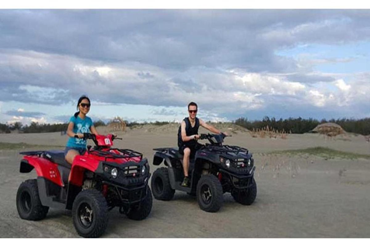two people riding on atvs on the beach
